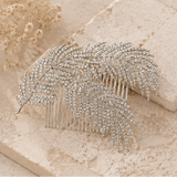 A four-panel collage showing a silver feather-shaped hair comb embellished with clear rhinestones, styled on beige stone and cream satin fabric.